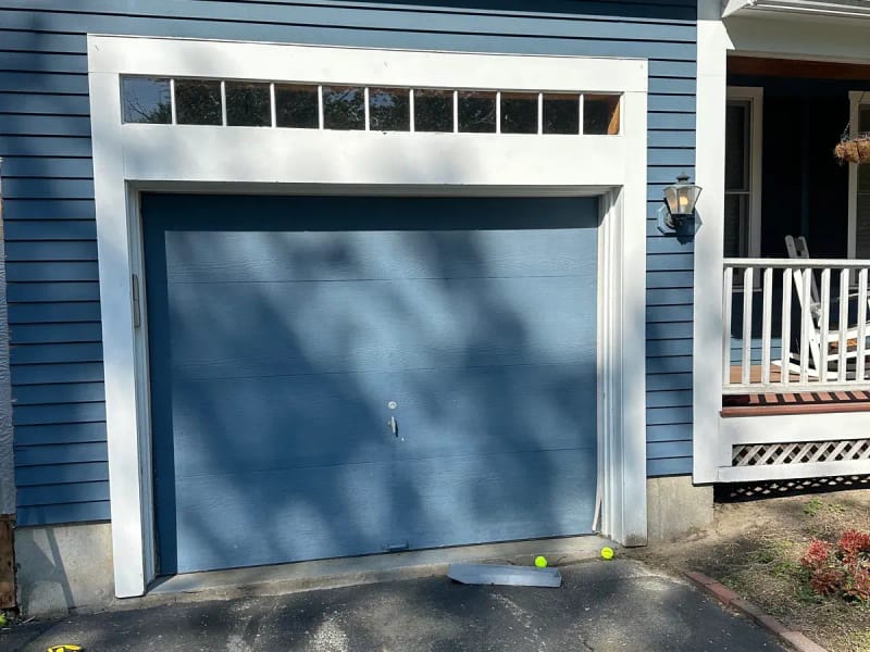 Original blue flush garage door on colonial home before dual door upgrade