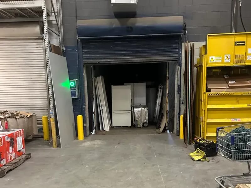 Commercial loading-bay roll-up door in open position inside warehouse workspace