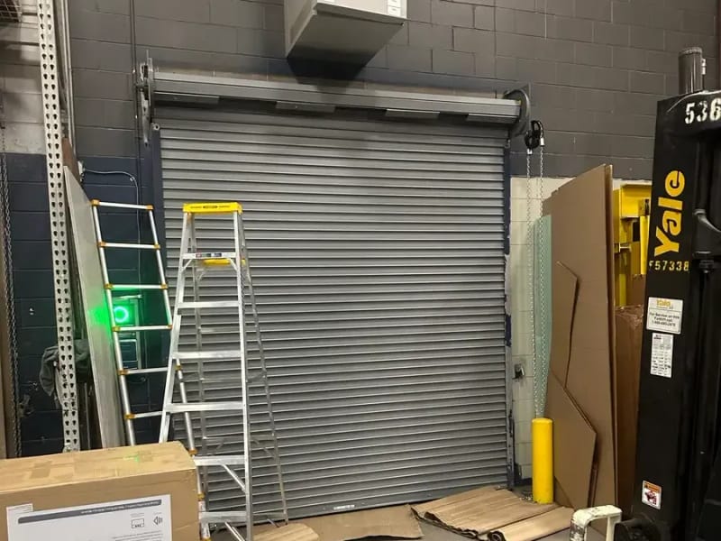 Closed gray commercial rolling steel door at industrial loading bay