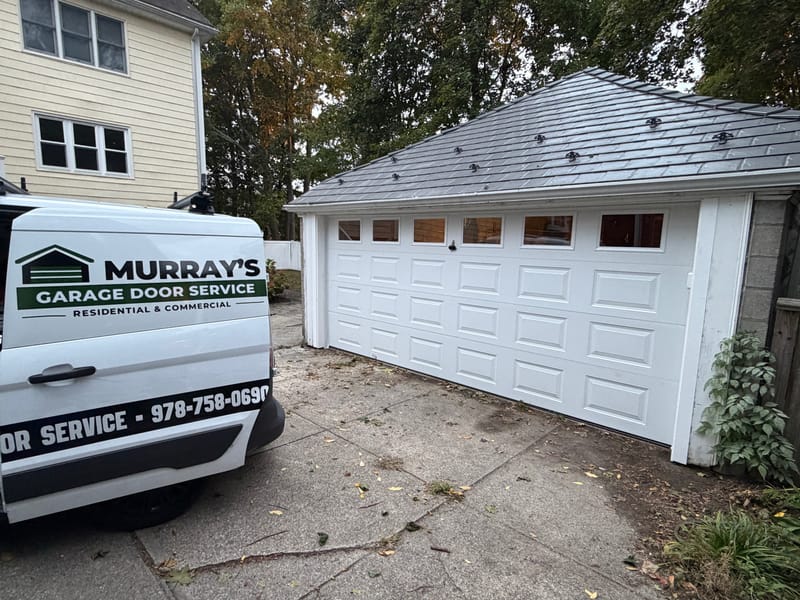 New white double garage door with windows on a detached garage, Murray's van parked beside it