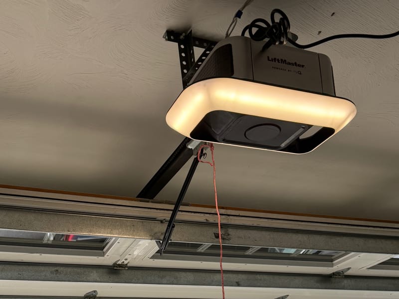 LiftMaster garage door opener with a lit LED ring on a garage ceiling