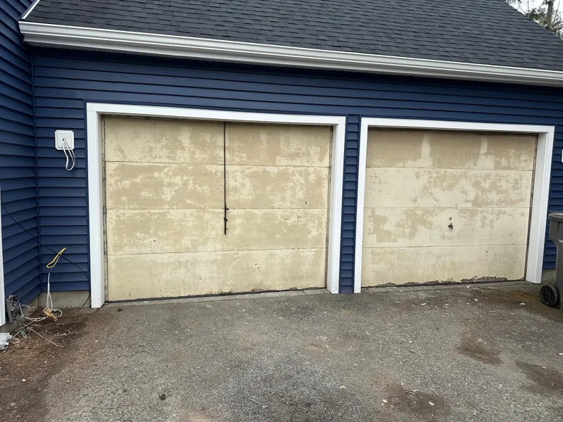 Before: two worn, faded garage doors on a navy two-car garage