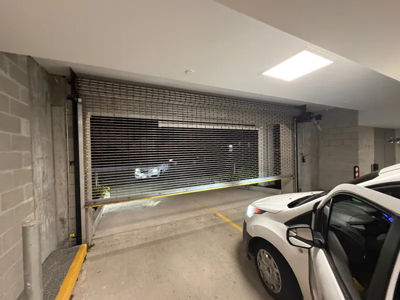 Rolling security grille closed across a parking garage entrance