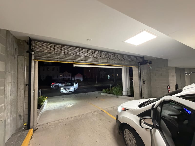 Rolling security grille raised at a parking garage entrance at night